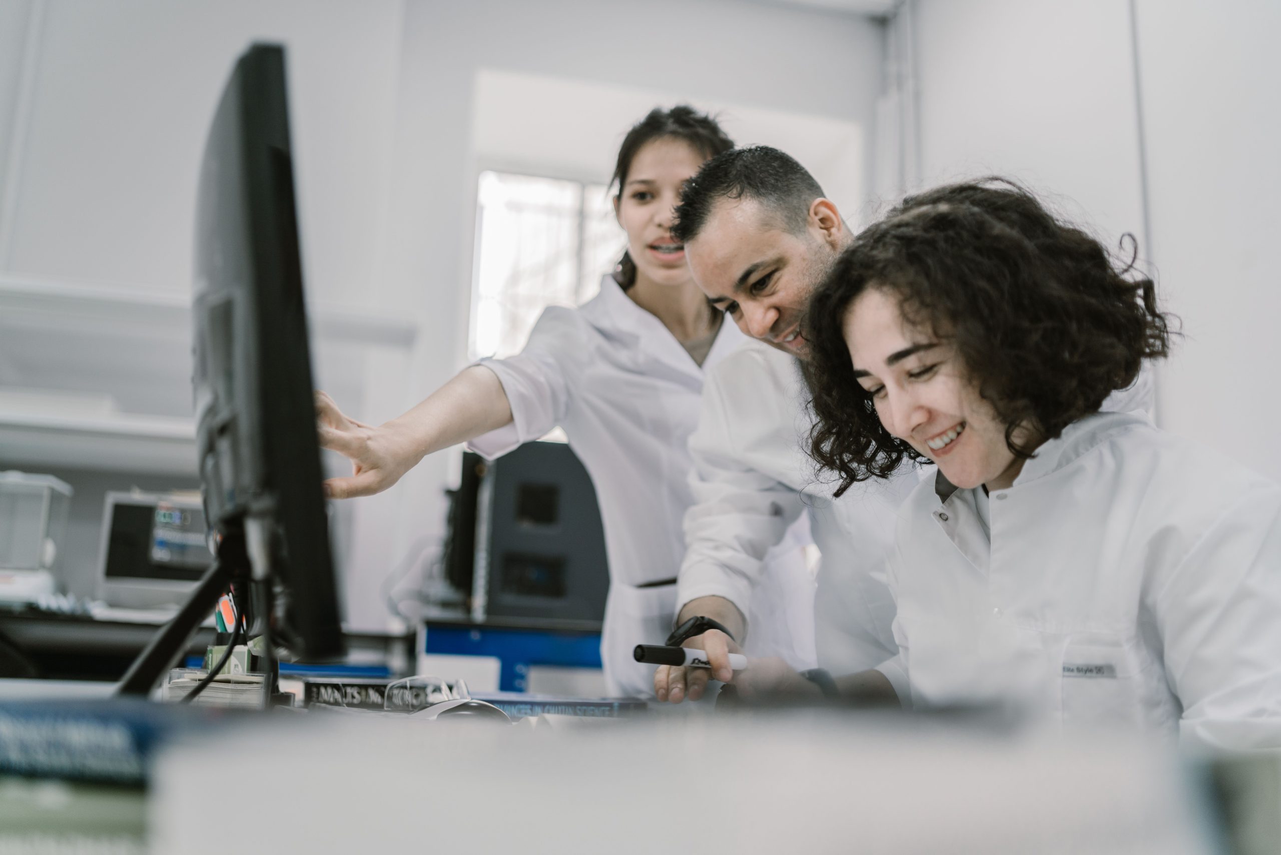features Group of diverse scientists working together on a computer in a bright, modern laboratory.